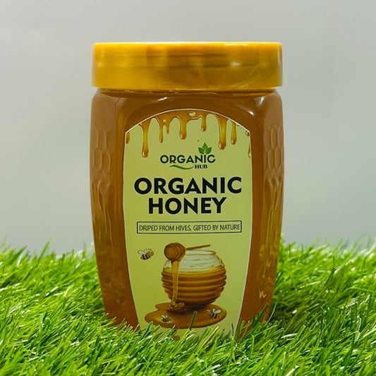 Jar of organic honey on grass with a white background